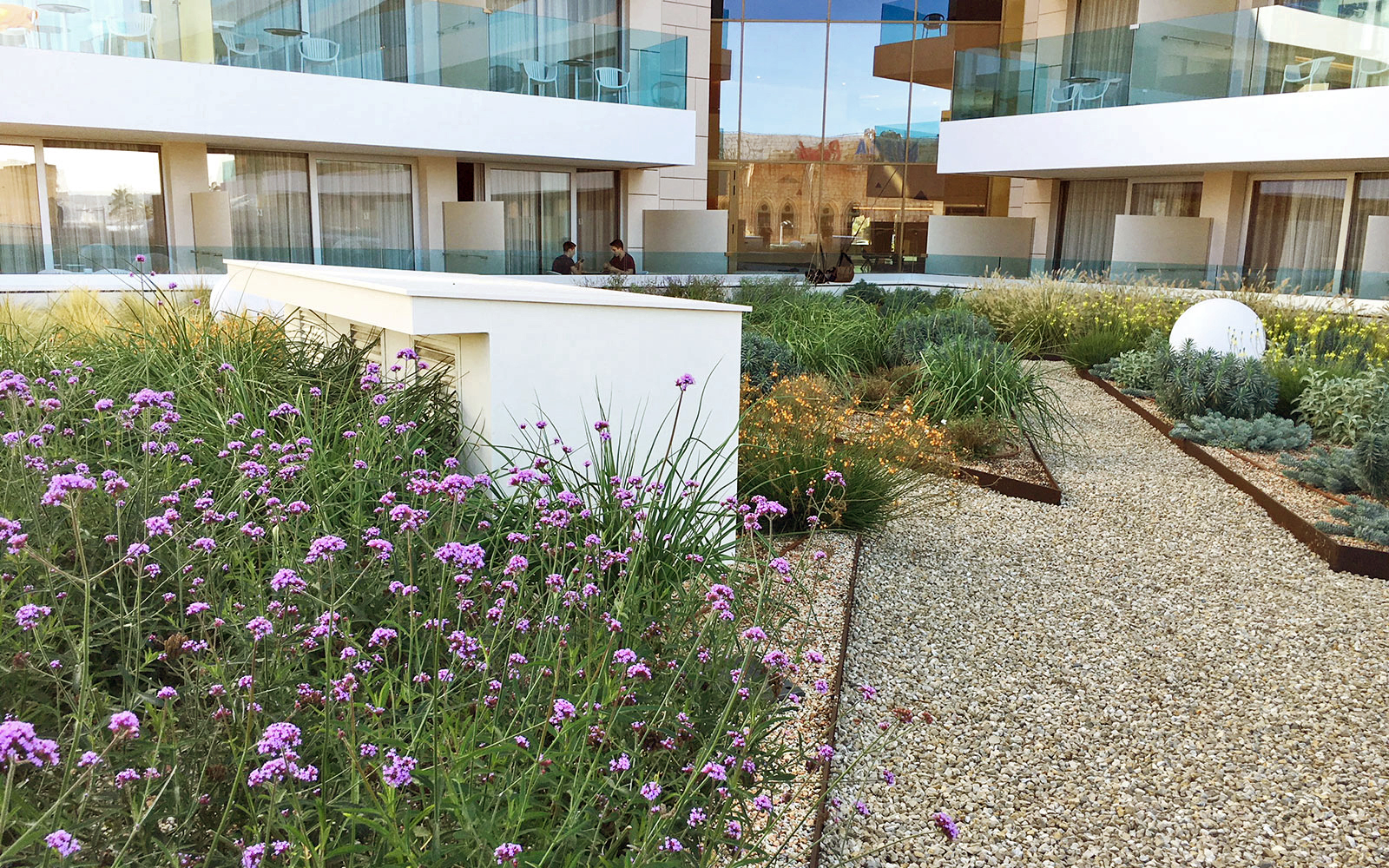 Roof garden with flower beds and a gravel path